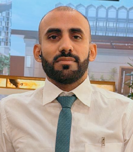 Portrait of Operations Manager Ijaz Ahmed wearing a light shirt and dark jacket